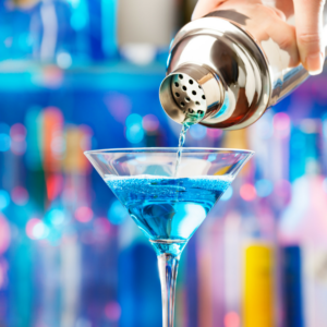 bartender pouring personalised blue cocktail drink in a glass
